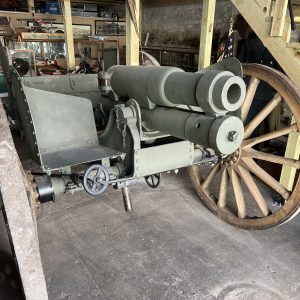 Vintage cannon on wooden wheels in historical exhibit.